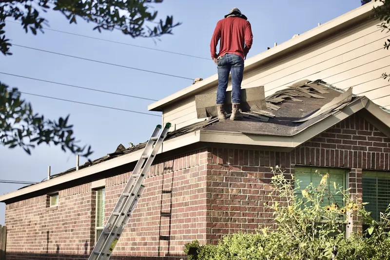 Professional roofer working on a residential roof in West Side Manor